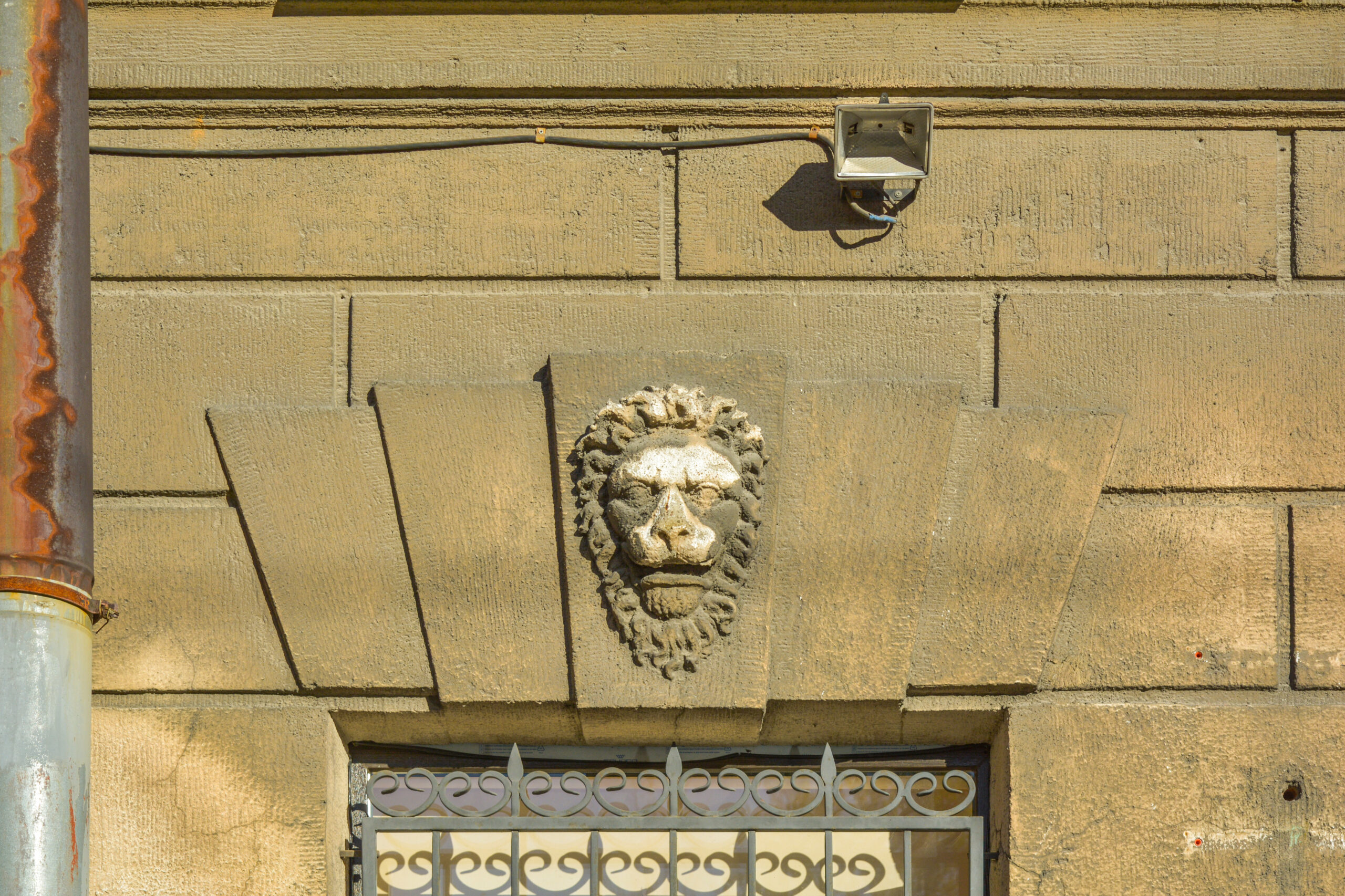 Window with stucco molding with lion head ornament above
